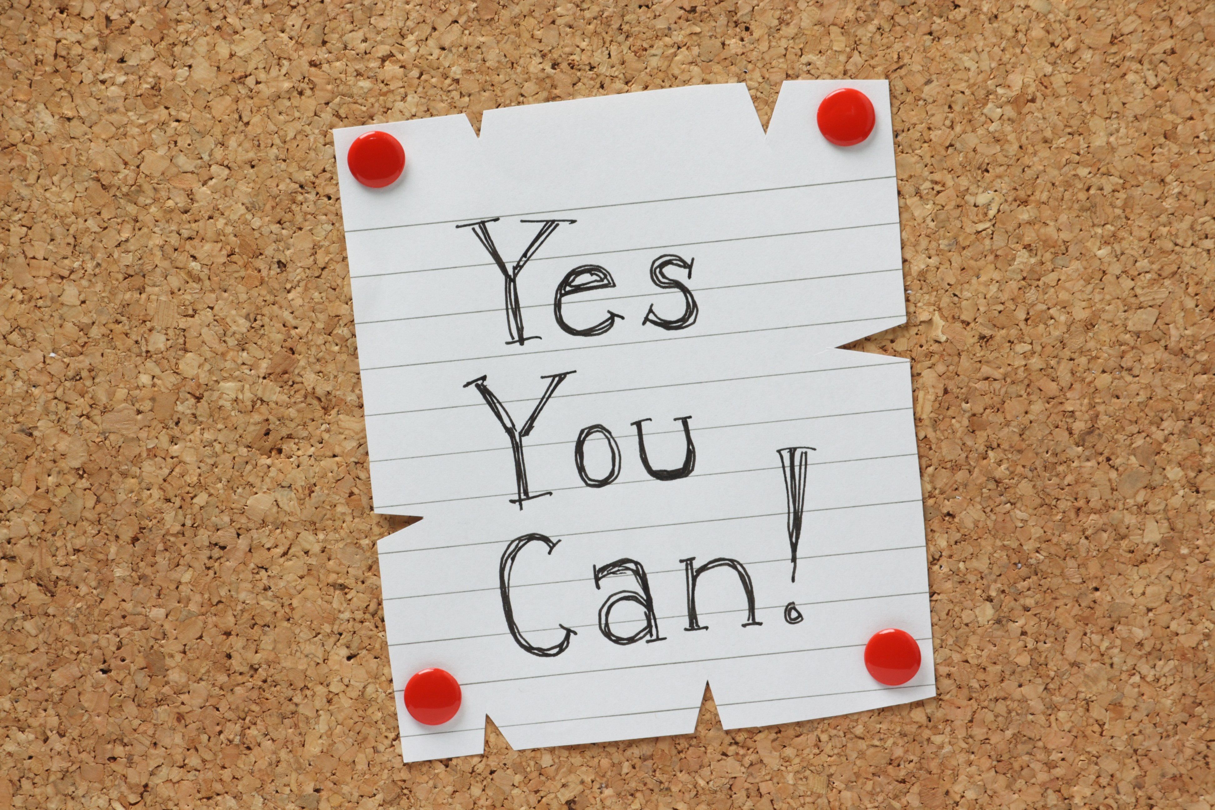 The phrase Yes You Can on a cork notice board