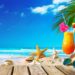 Straw hat with sunglasses and cocktail on sand beach. Summer Holidays concept