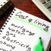 Cost of living written in a notebook and calculations of home finances.