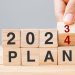 hand flipping block 2023 to 2024 PLAN text on table. Resolution, strategy, goal, motivation, reboot, business and New Year holiday concepts