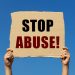 Stop abuse text on box paper held by 2 hands with isolated blue sky background. This message board can be used as business concept to say no to abuse.